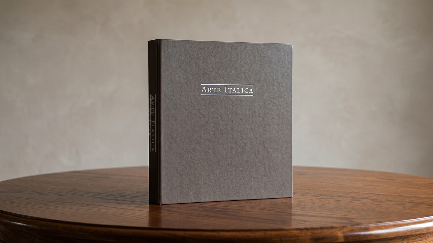 Photo of Arte Italica print catalog on oak table and neutral background